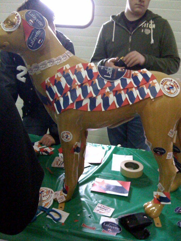 Teenagers gathered around a fake, plastic dog